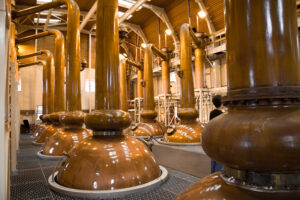 View of copper whiskey stills in a distillery - Whisky Geschichten