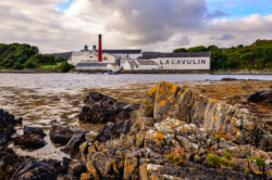 Lagavulin-Brennereifabrik mit Meeresküstenvordergrund, Islay, Vereinigtes Königreich